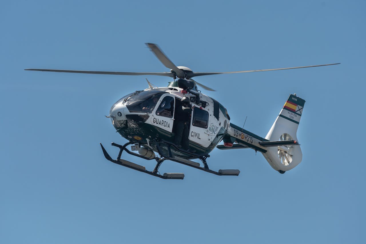 Spanish Guardia Civil helicopter flying against a clear blue sky in San Javier, Spain.